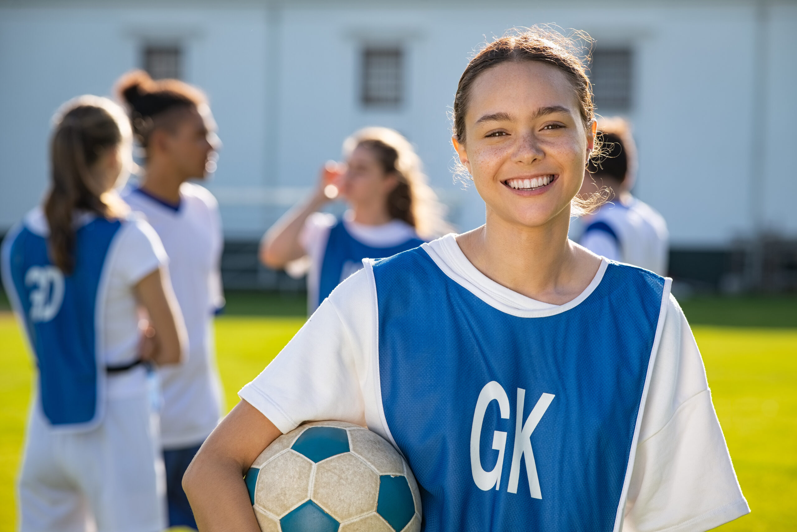 cheerful,soccer,player,holding,a,football,and,looking,at,camera.